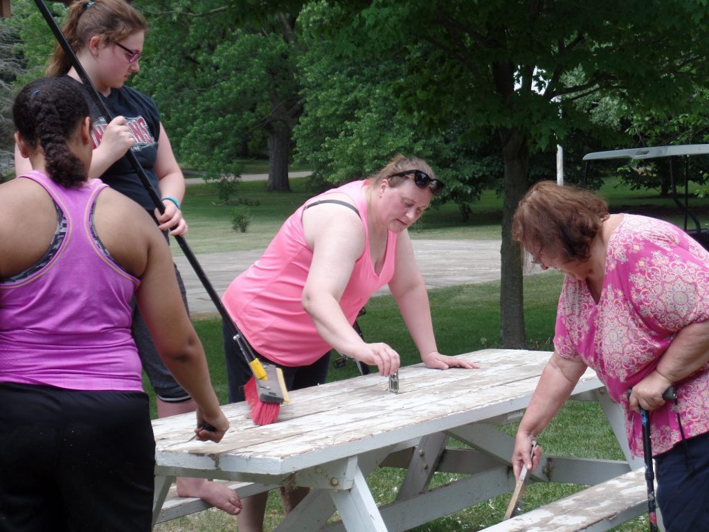 Volunteers painting picnic table at Plover City Park